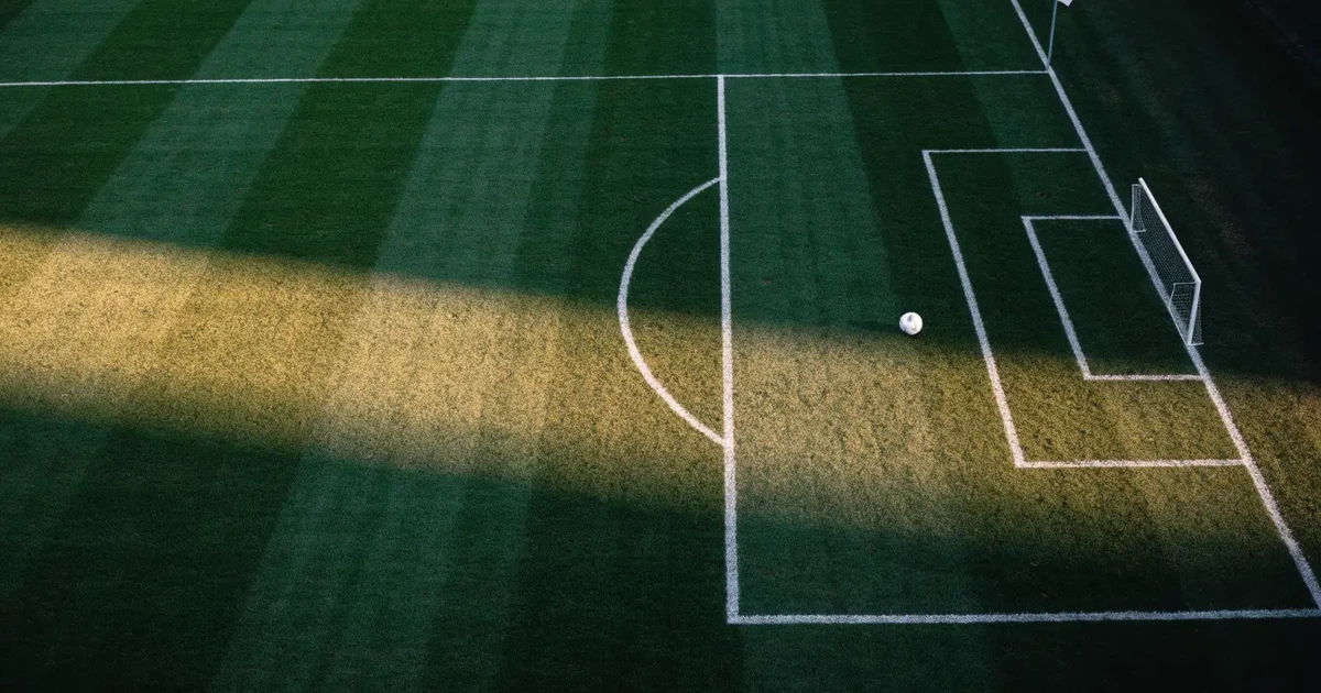 Ein Spielfeld aus der Vogelperspektive mit frisch gezogenen weißen Linien, ein einzelner Ball liegt im Strafraum, niemand ist zu sehen.